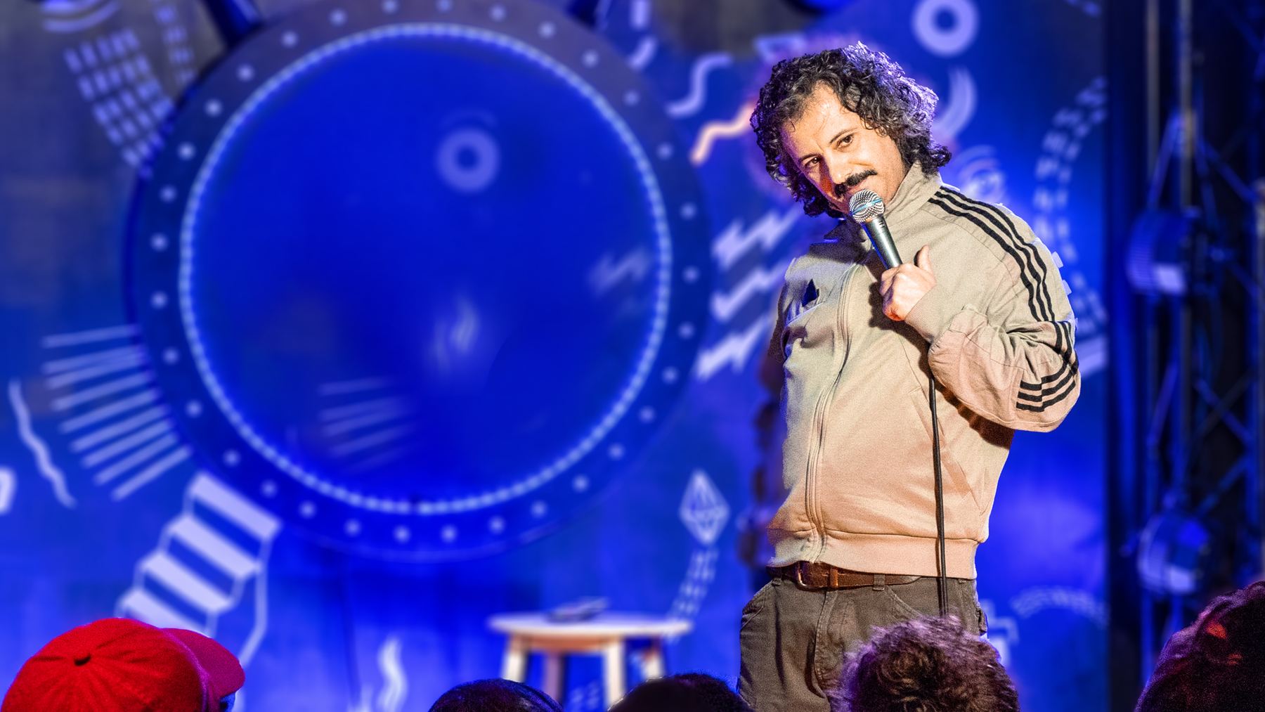 Comedian auf der Bühne des Chaos Comedy Club vor vollem Haus